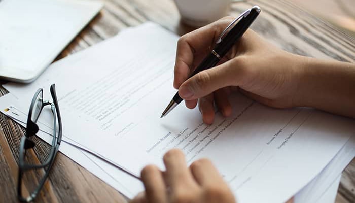 businessman-examining-papers-min